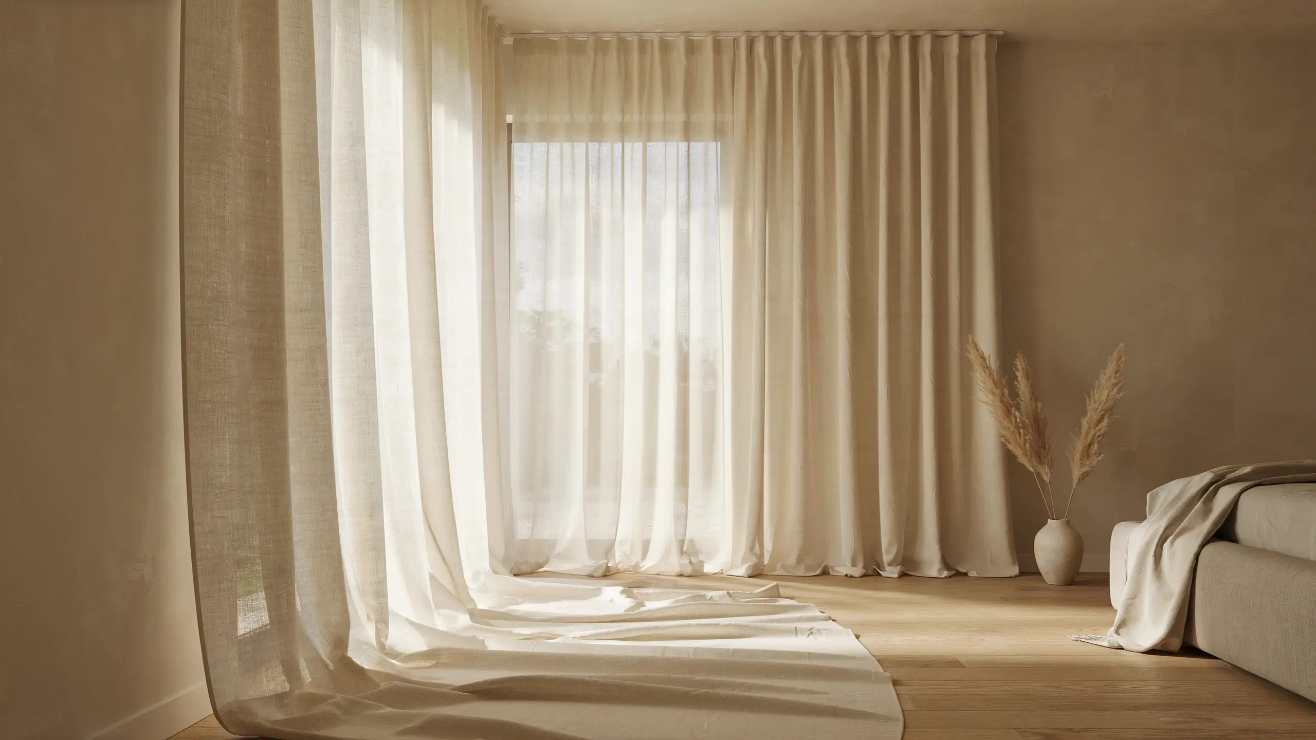 Sunlit sheer linen floor-to-ceiling curtains pooling on light oak flooring in a minimalist living room with pampas grass.