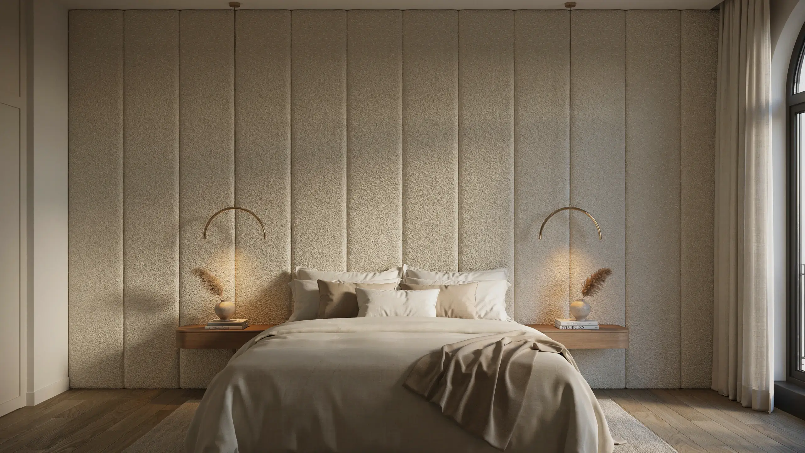 Serene minimalist bedroom featuring a floor-to-ceiling upholstered headboard with vertical beige textured panels, complemented by floating wood nightstands, curved brass wall sconces, and dried pampas grass, highlighting organic modern interior design.