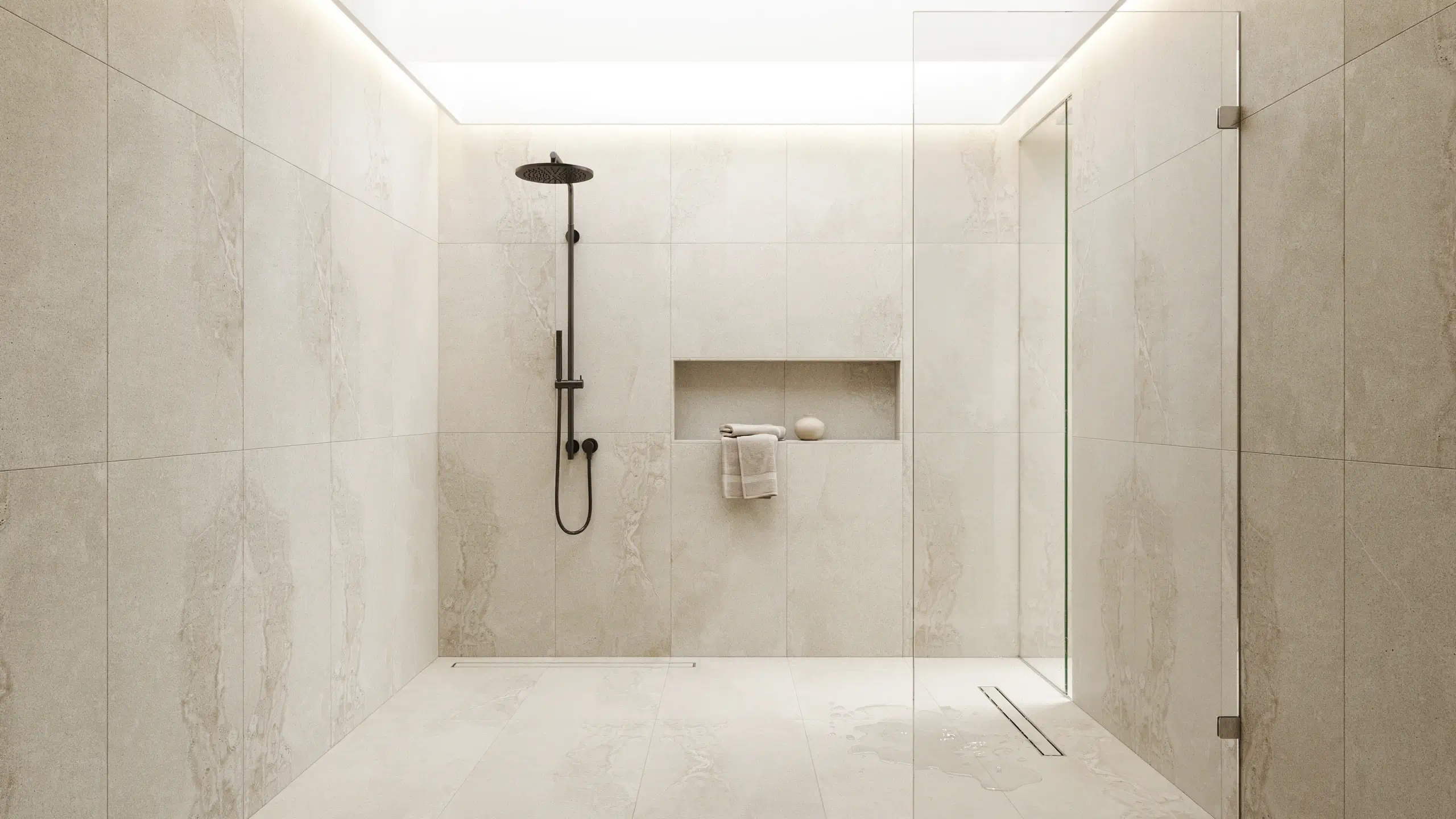 Modern walk-in shower featuring seamless large format floor-to-ceiling porcelain stone slabs, a matte black rain showerhead system, and a recessed wall niche with rolled towels.