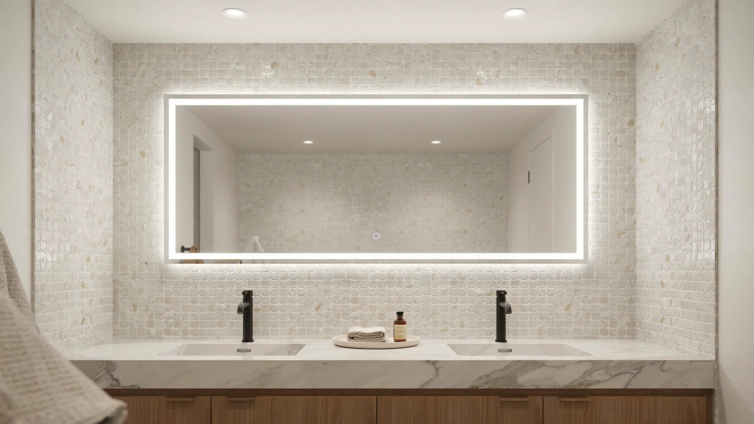 Modern bathroom double vanity featuring a large rectangular LED backlit mirror serving as the central focal point, styled with a white mosaic tile wall, marble countertop, double undermount sinks, and sleek matte black faucets.