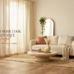 A bright, airy living room styled on a budget featuring a cream boucle sofa, jute rug, and pampas grass, showcasing 16 easy tricks to make a home look more expensive.