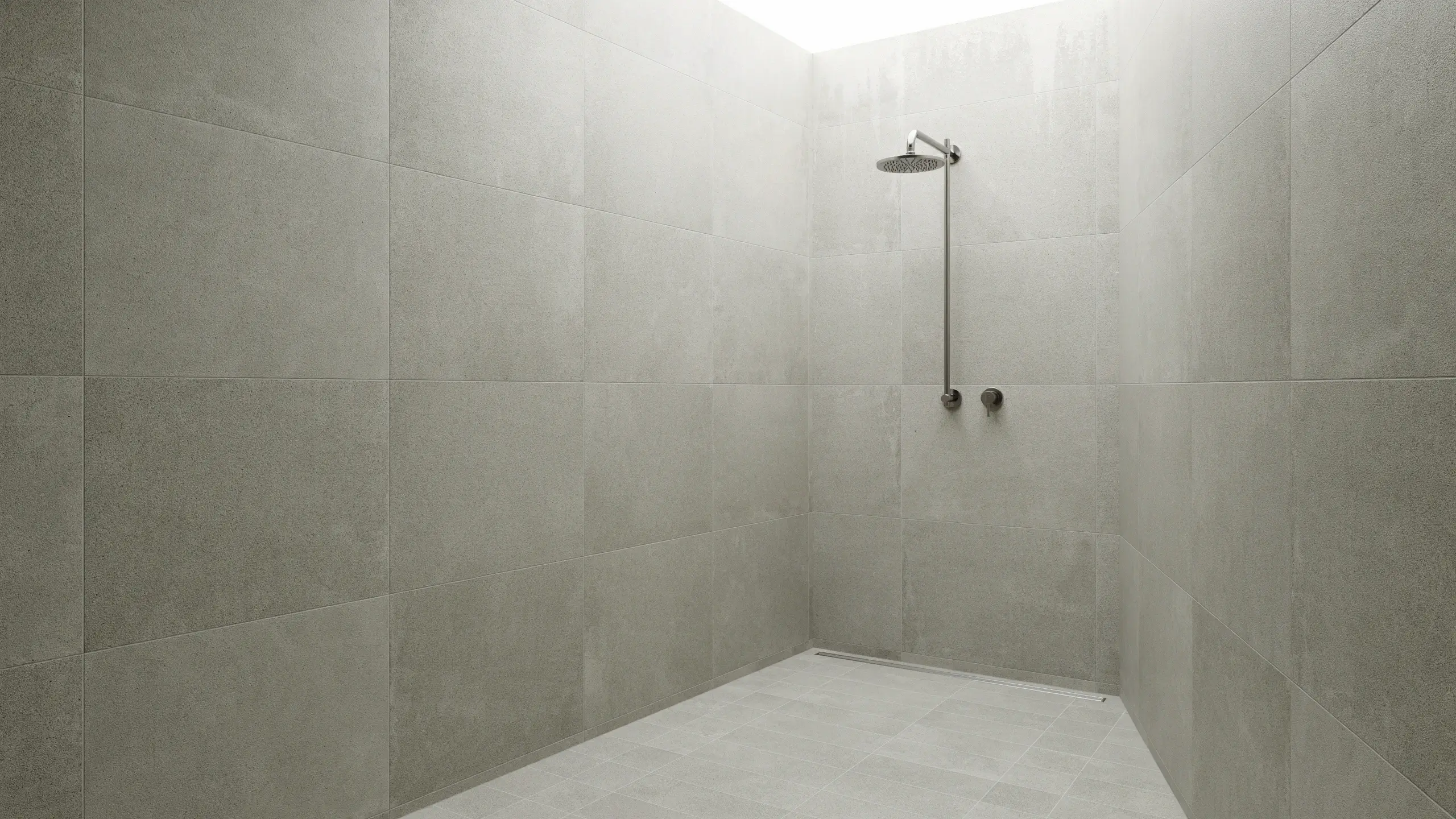 A minimal, modern walk-in shower lined with large-format, matte greige floor-to-ceiling wall tiles, featuring an exposed chrome rain showerhead, dual thermostatic controls, and a sleek linear floor drain, illuminated by bright natural light from a skylight.