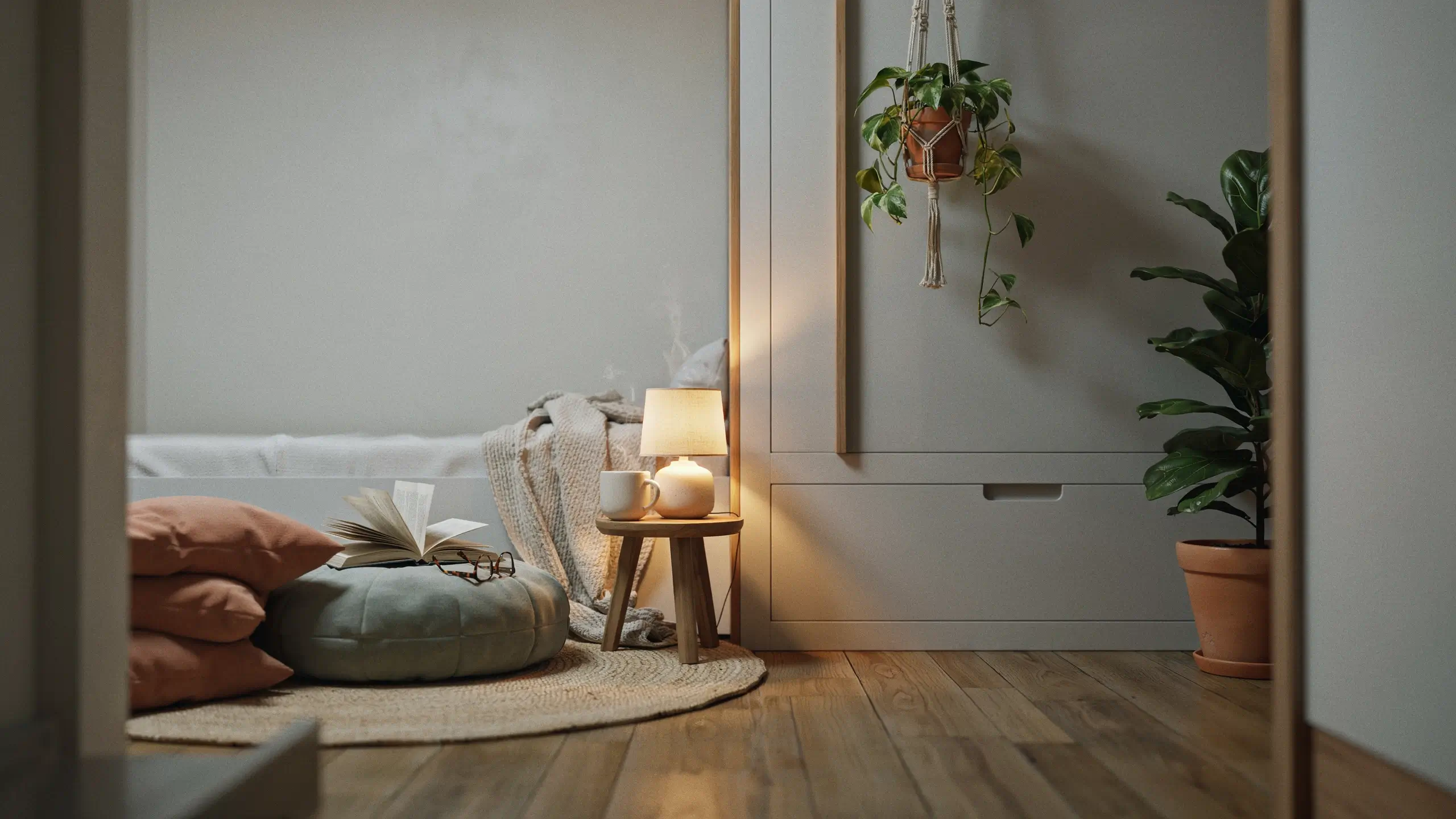 Closed white Murphy bed in a cozy bedroom nook with a floor pouf, open book, and warm table lamp.