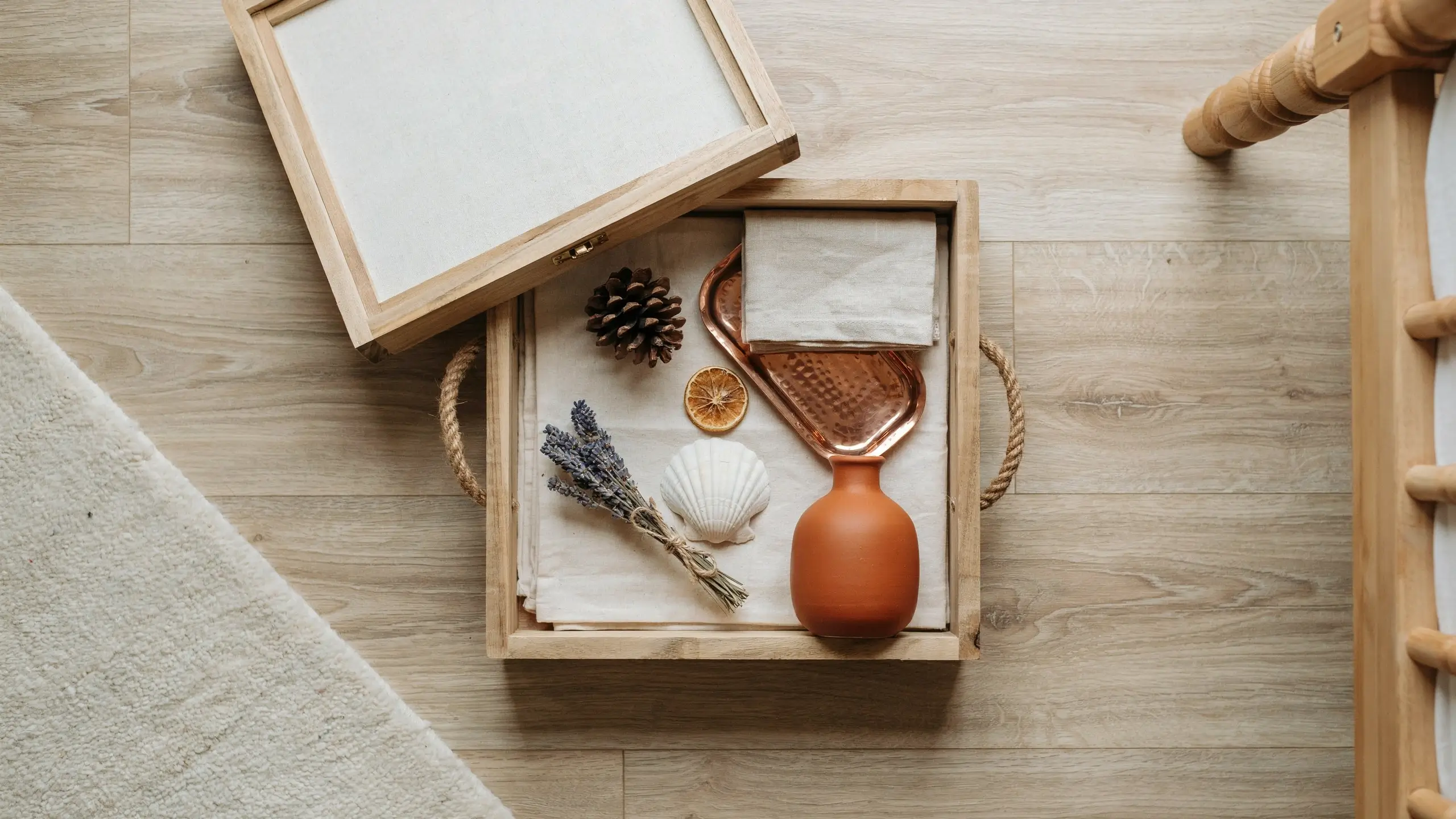 Natural wooden tray styled with terracotta vase, dried lavender, pinecone, seashell, and copper dish for a seasonal decor swap. 