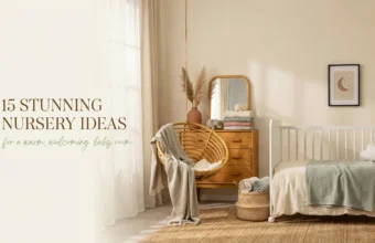 Warm, neutral boho nursery decor featuring a white crib with a cloud pillow, a hanging rattan chair draped in a beige throw, a wooden dresser with pampas grass, and soft sunlight filtering through sheer white curtains.